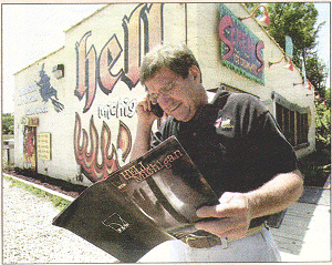 Look of horror: Mr Colone reads a comic outside his souvenir shop